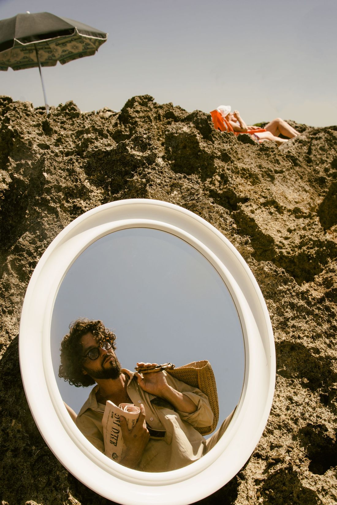 Matteo Capreoli im Spiegel auf den Felsen am Meer